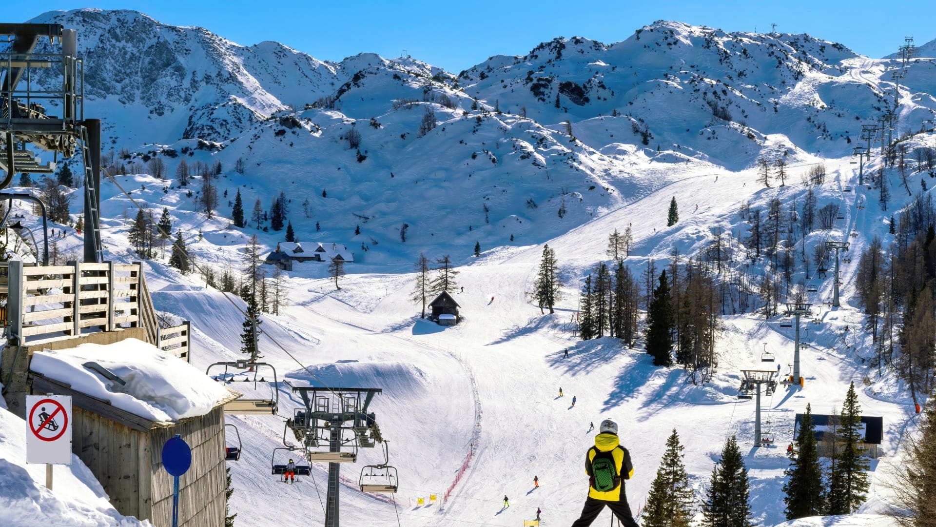 Sunny panoramic ski slope with chairlift line above the Julian Alps, similar to the view from Vogel