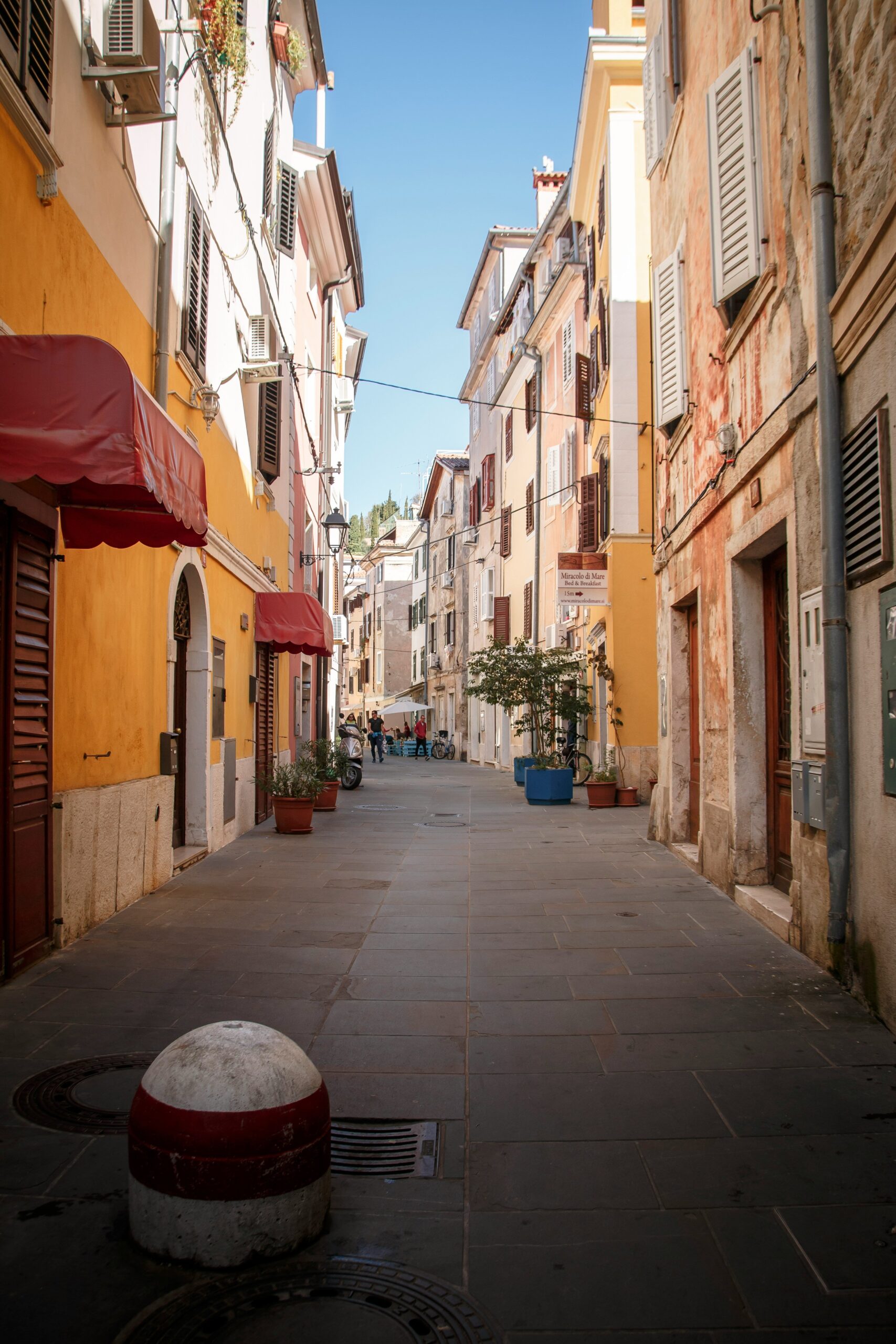 Étroite ruelle de pierre dans la vieille ville de Piran avec balcons et cordes à linge