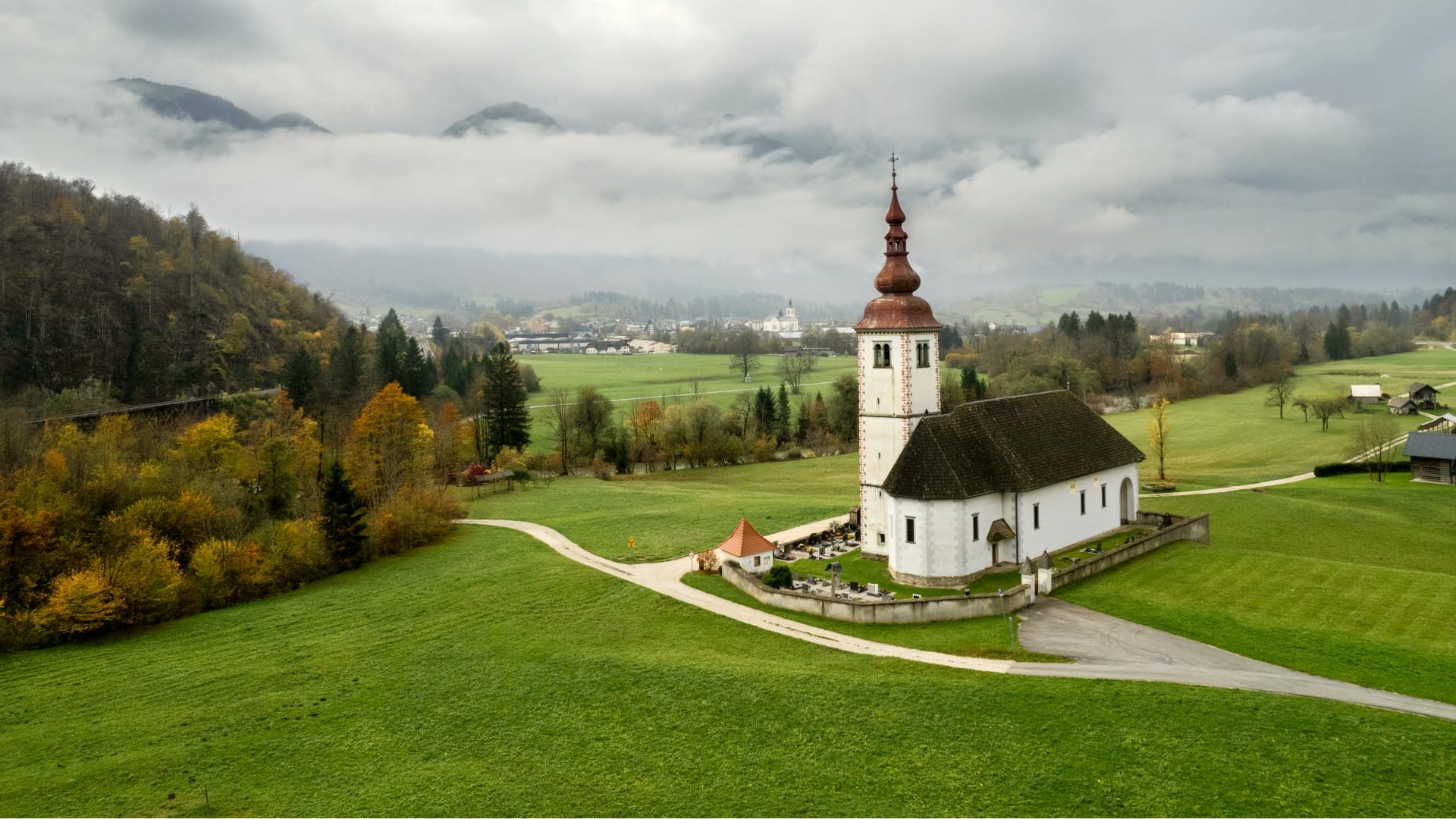 Aerial view of a church and cemetery in the Bohinj valley near Bohinjska Bela