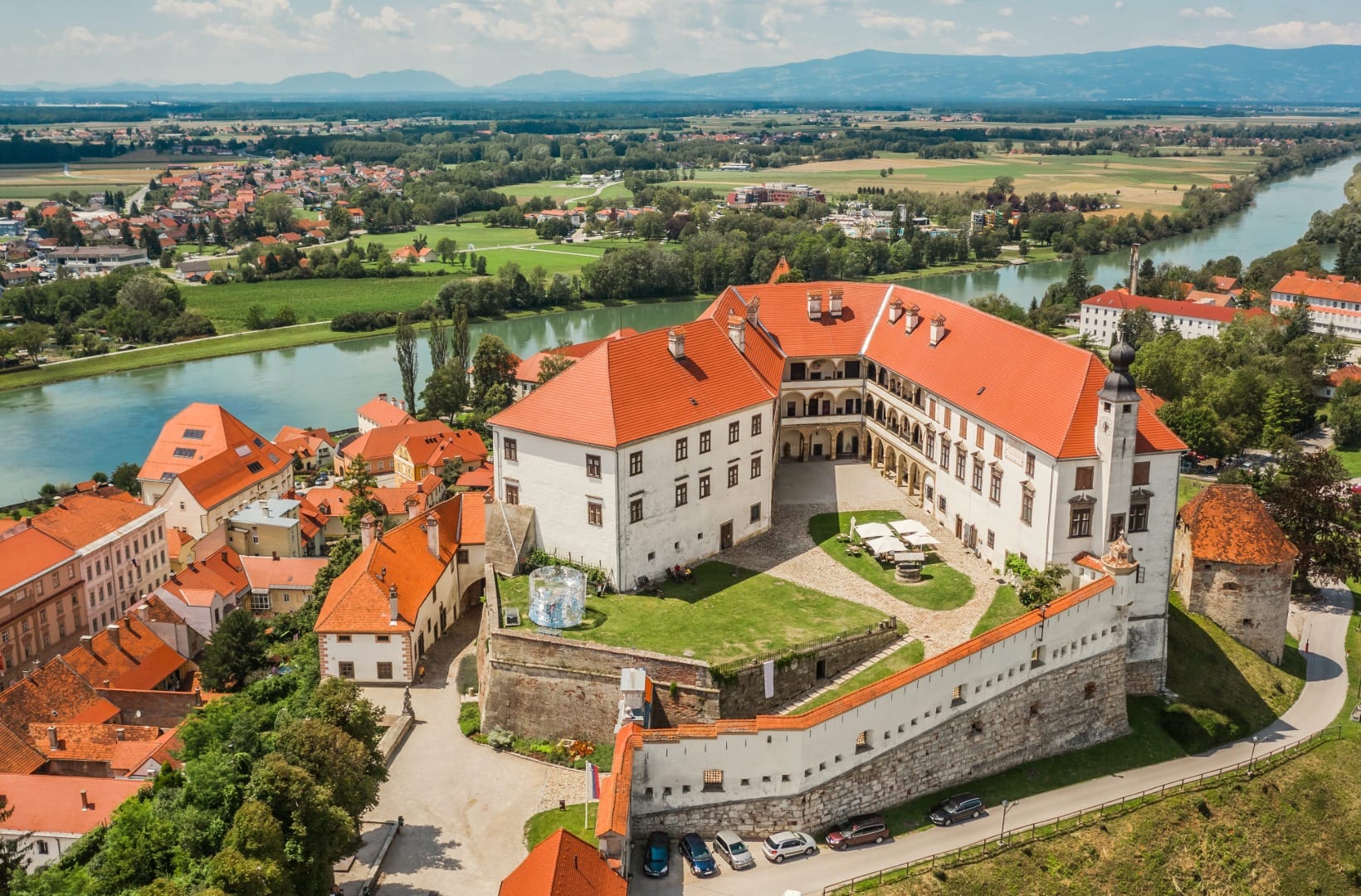 Aerial view of Ptuj Castle with its arcaded courtyard, the Drava river curving behind