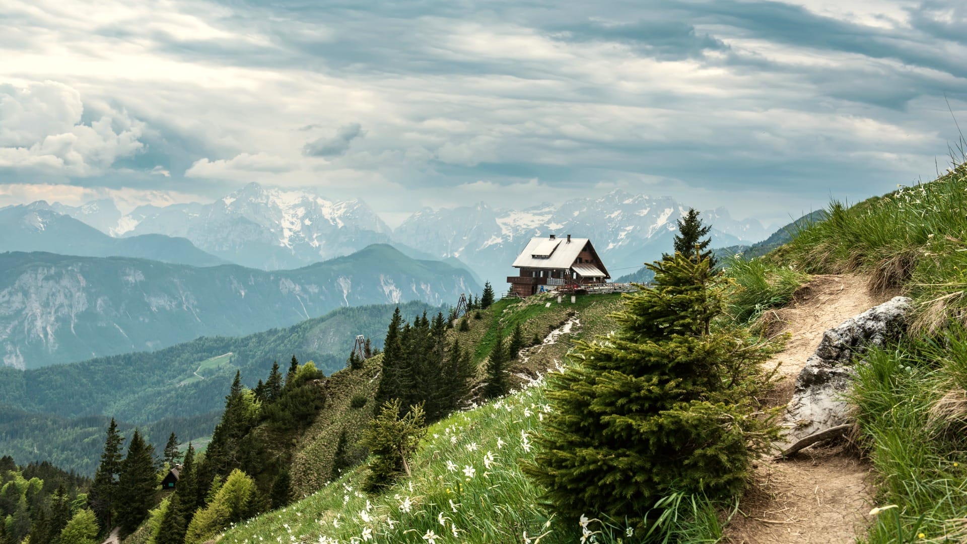 Koča na Golici mountain hut with the snow-capped Julian Alps in the background