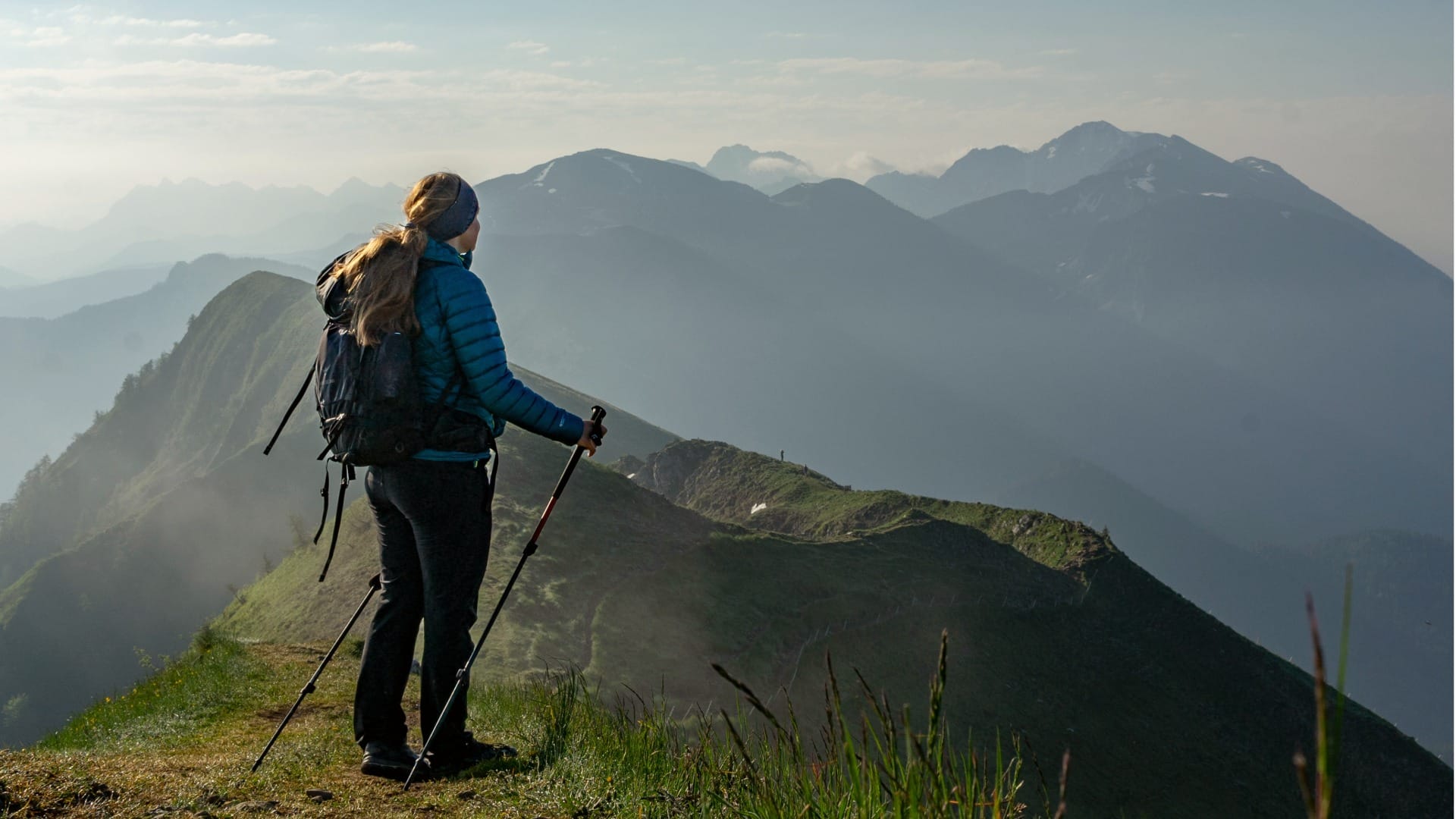 Hiker with trekking poles taking in the panoramic view from the Golica summit ridge