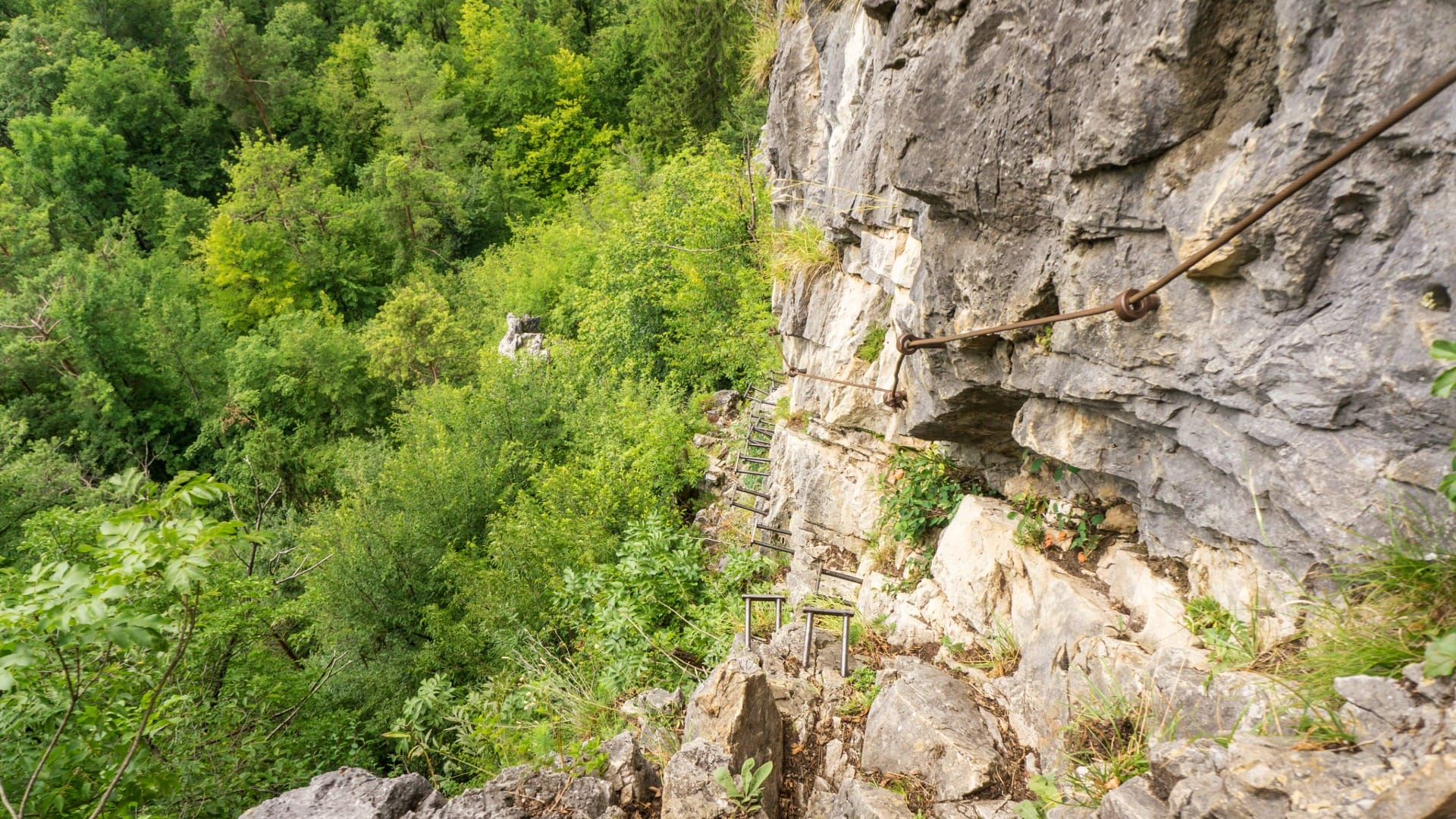 The steel cable and metal rungs on the short secured rock step near the ridge