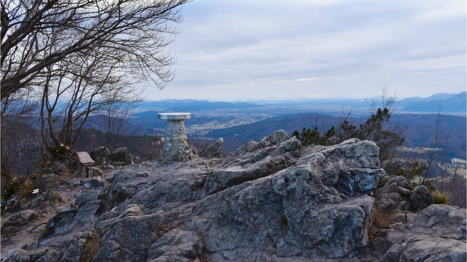 The summit viewpoint disc and panoramic view from Polhograjska Grmada