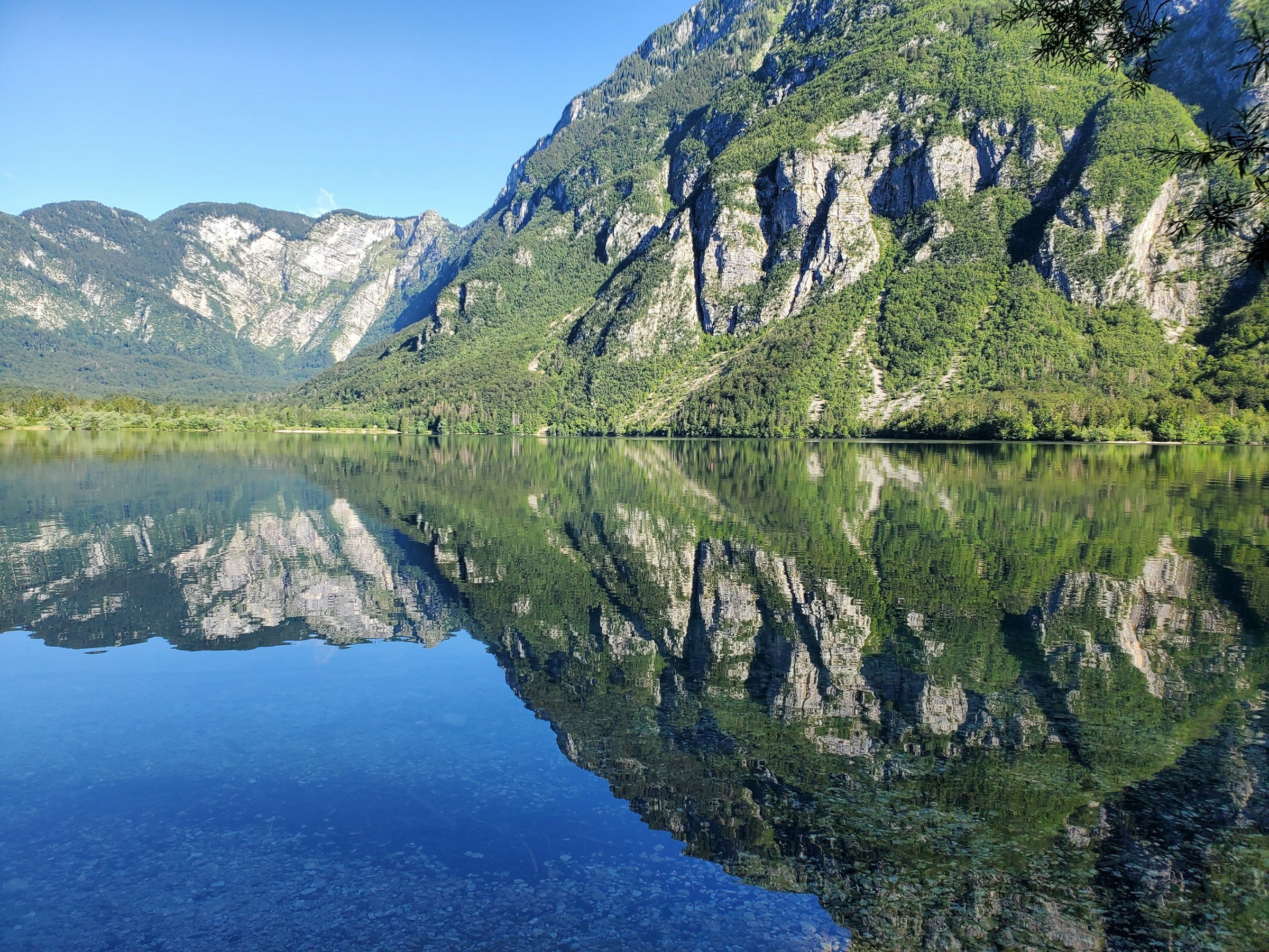 Iglesia y puente de piedra en el lago Bohinj