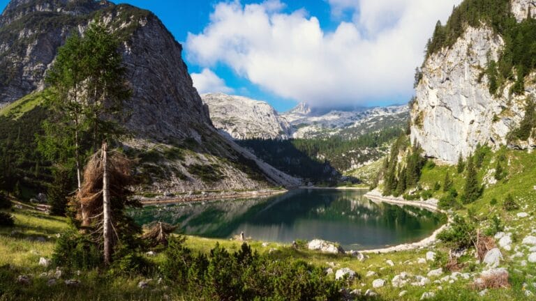 Emerald waters of Krnsko jezero with the mountain hut visible on the far shore
