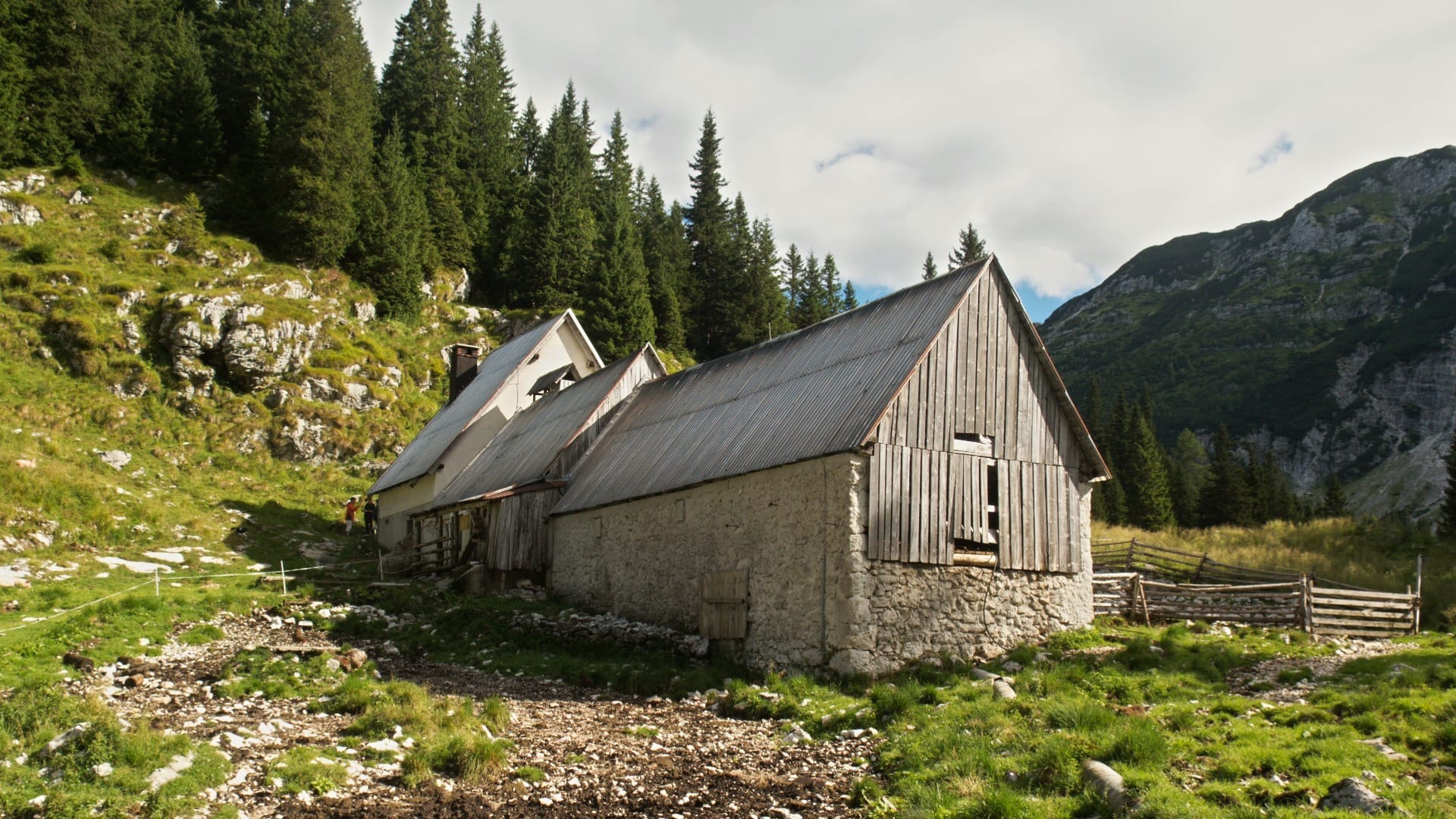 Traditional stone-and-timber mountain hut buildings at Planinski dom pri Krnskem jezeru