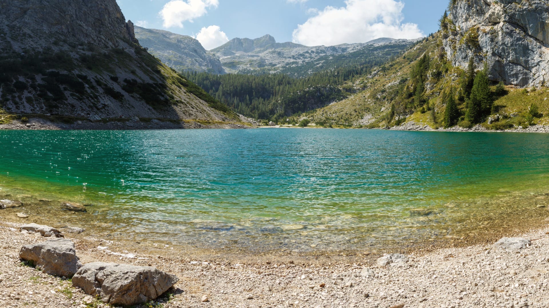 Clear turquoise water of Krnsko jezero with the peaks of Mount Krn rising behind