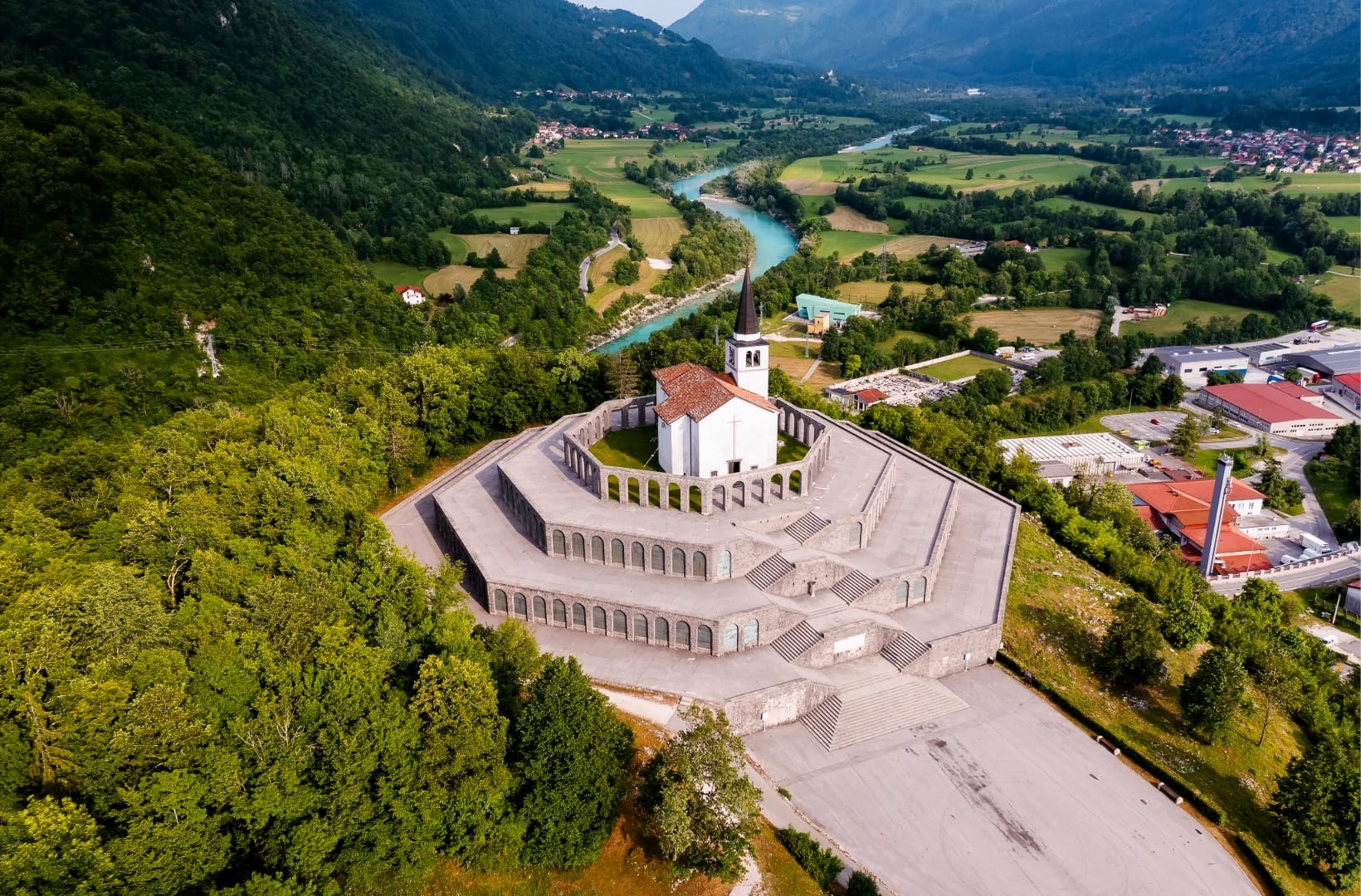 The tiered octagonal Italian Charnel House above Kobarid, the church of St Anthony on top, the emerald Soča winding through the valley behind